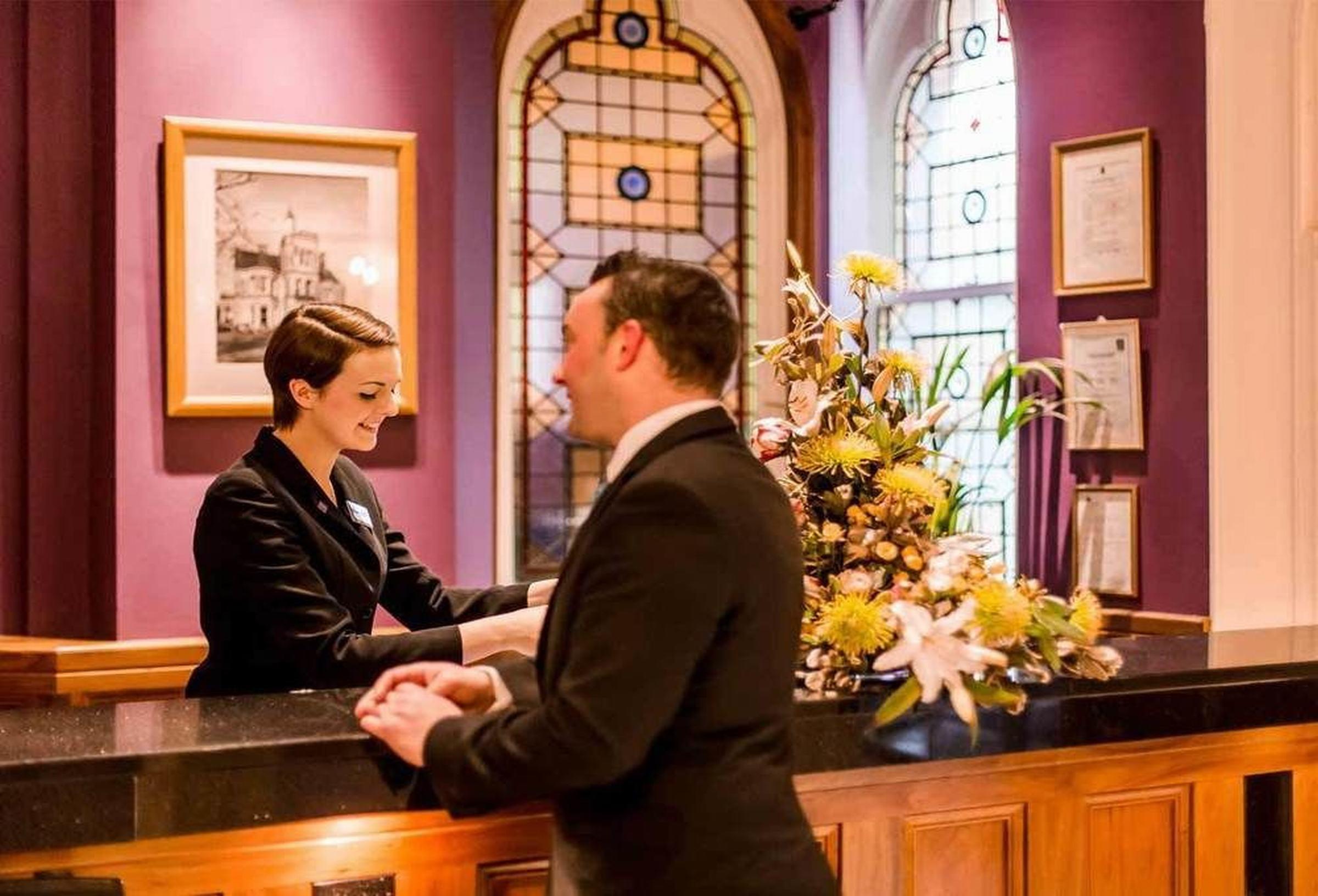 The Culloden Estate And Spa Холівуд Екстер'єр фото A hotel receptionist at work